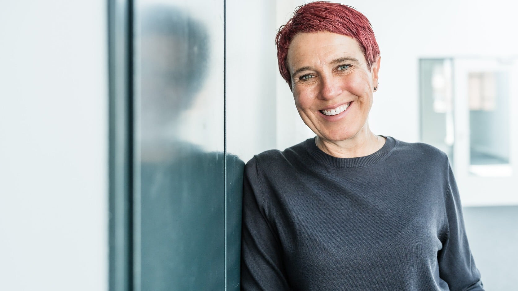 Nadine Pötz steht lächelnd in einem hellen Innenraum.